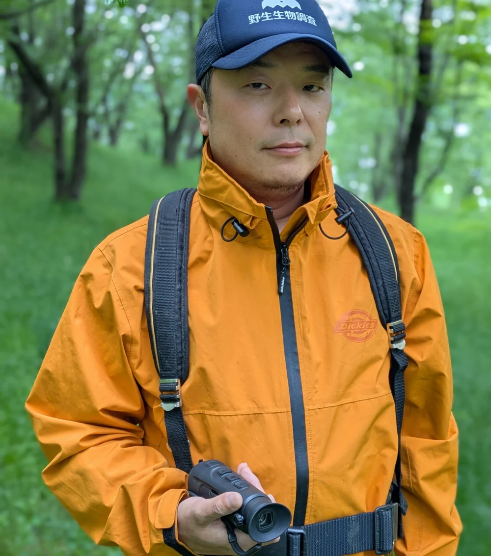 事業紹介と実績|かわほりプリベント 1 山岸淳一(調査機器を手に持ち現場で立つ様子)